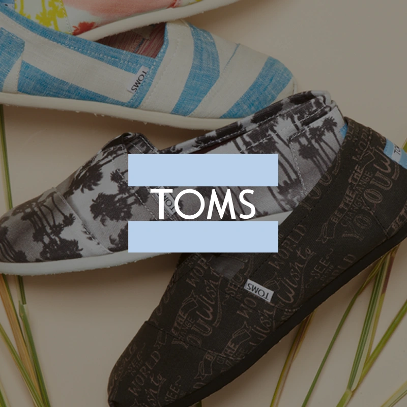 TOMS logo over patterned slip-on shoes.