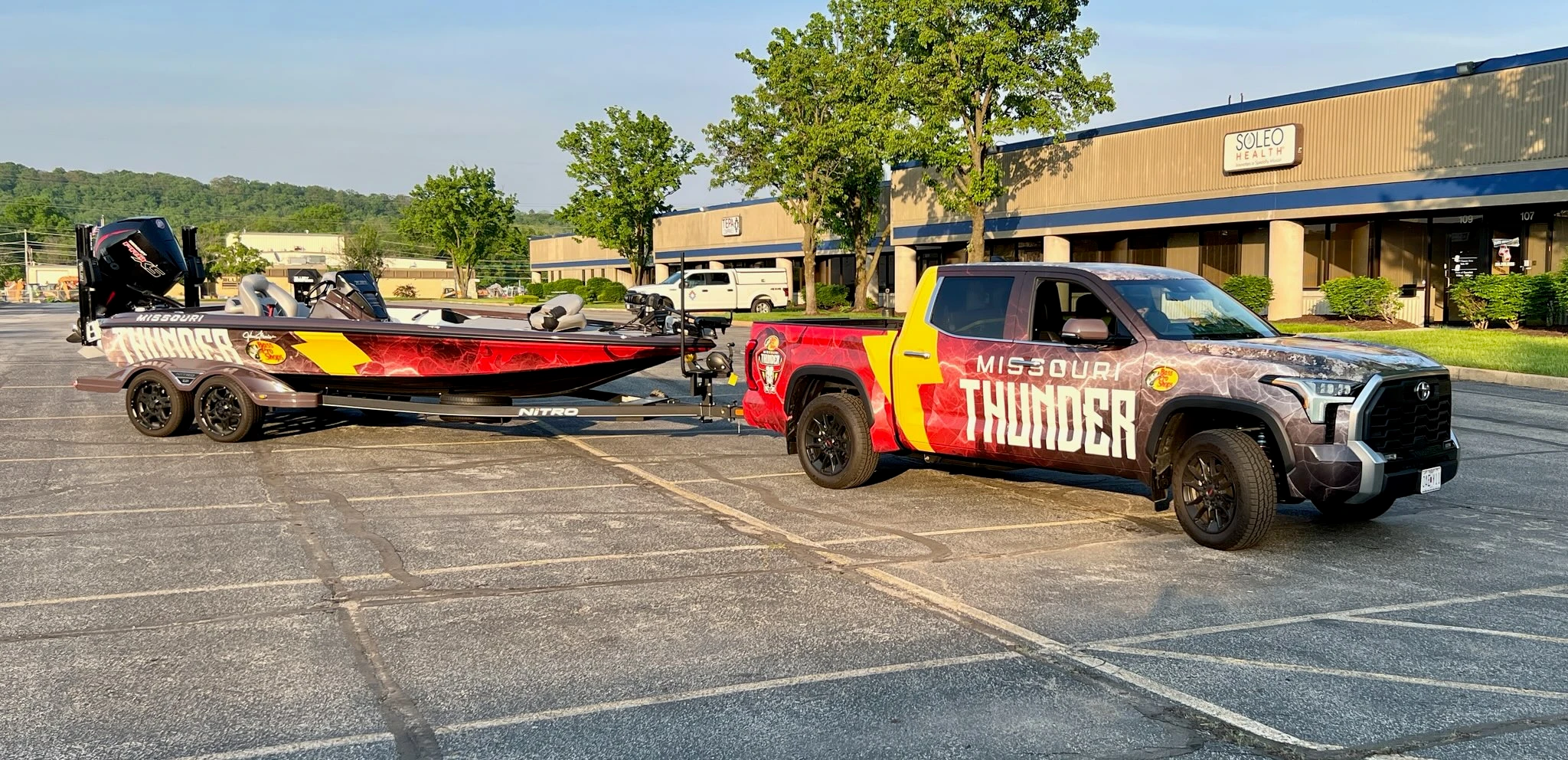 Photograph of the branded Missouri Thunder truck and boat outdoors.